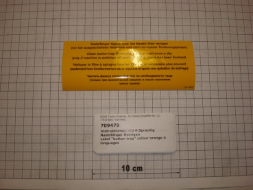 Label "button trap" colour orange 4 languages